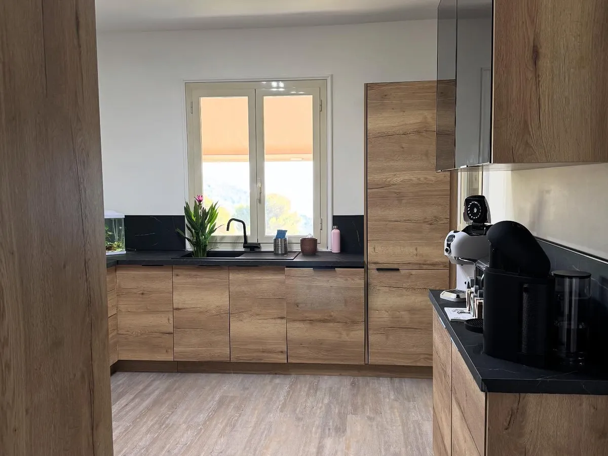 Cuisine rénovée par ATM, façades bois et plan de travail noir