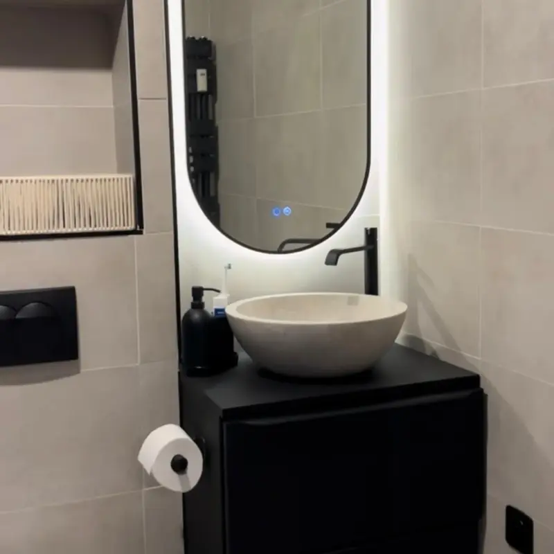 Salle d'eau rénovée par ATM, vasque en pierre et miroir lumineux