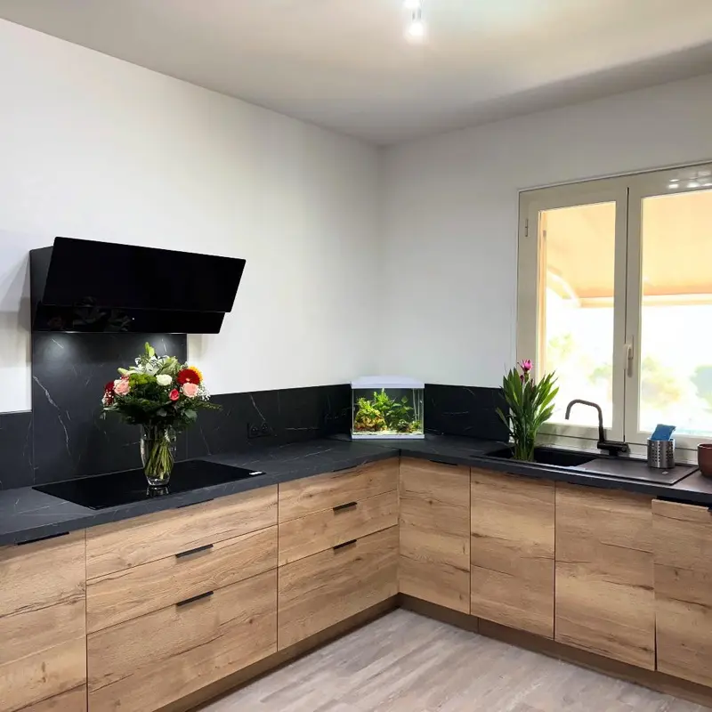Cuisine rénovée par ATM à Monaco, façades chêne et plan de travail effet marbre noir